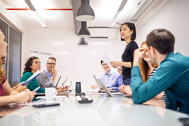 coworkers sitting around a table in discussion in a conference room