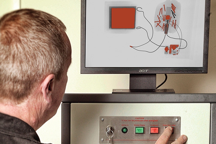 man operating a security scanner to see what is inside a parcel